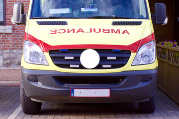 Moderner belgischer Krankenwagen oder Rettungswagen in den Farben Gelb und Rot parkend auf Parkplatz