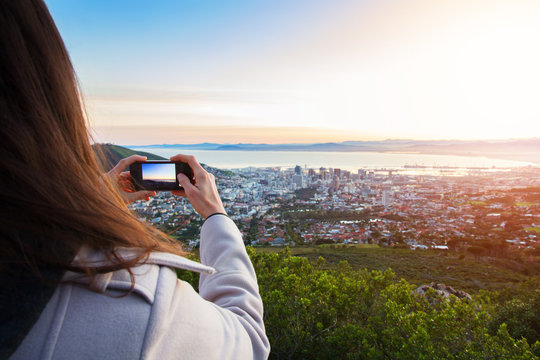 Tourist taking a photo on phone of Cape Town view