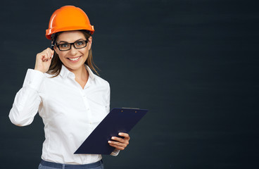 Smiling builder woman holding clipboard with pen.