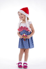Girl in santa hat. in full growth in polka-dot dress with a toy owl in the hands of the playful toddler