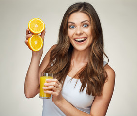 smiling woman holding orange juice glass with half orange fruit.