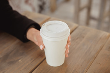 Obraz na płótnie Canvas Hands with a take away coffee cup