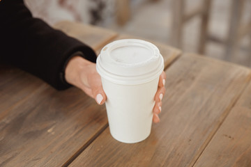 Fototapeta na wymiar Hands with a take away coffee cup