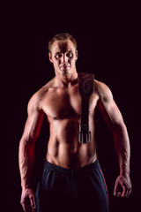 Fototapeta na wymiar Muscular man in with lifting belt posing over dark background.