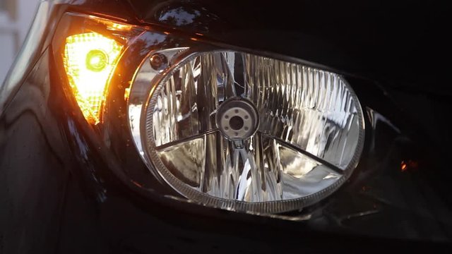 Detalle Intermitente delantero de coche luciendo, y faro apagado