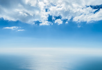 cloudy blue sky and the sea divided by the line of the horizon