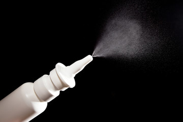 Close-up of nasal drug spraying on black - obrazy, fototapety, plakaty