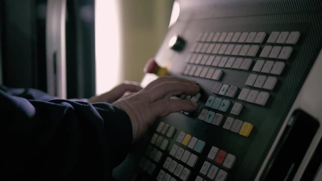 Operator controls the modern cnc machining center. Selective focus on hand.