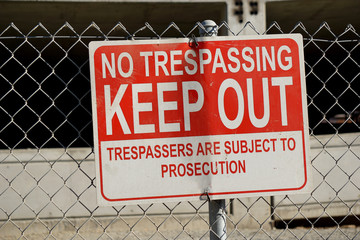 no trespassing sign on fence of construction site - obrazy, fototapety, plakaty