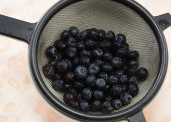 Freshly rinsed blueberries in strainer in white bowl
