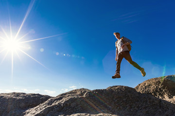 Man jumping over gap on mountain hike