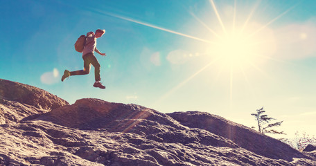 Man jumping over gap on mountain hike