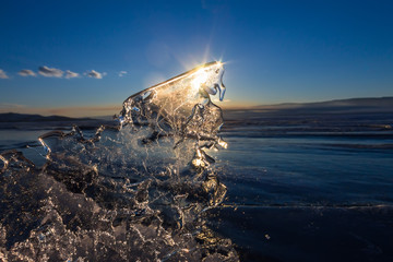 Sun at sunset shining through the transparent texture of the ice