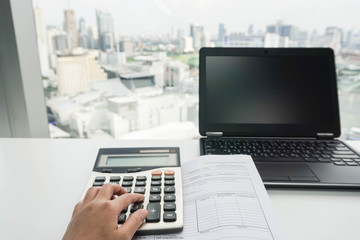 businesswoman use calculator with laptop for paperwork
