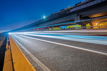 blurred traffic light trails on road at night in China.