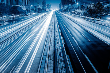 blurred traffic light trails on road at night in China.