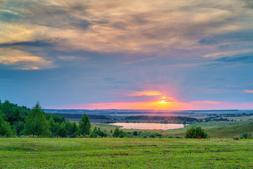 Obraz premium Beautiful sunset over lake in a countryside
