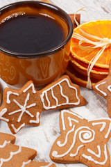 Fresh gingerbread, cup of coffee and spices on old wooden background, christmas time