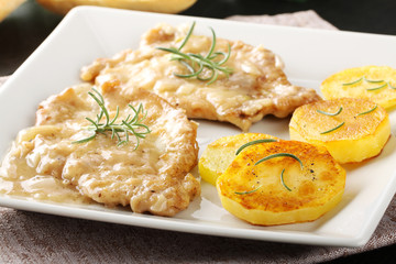 Scaloppina with rosemary with baked potatoes - 124572735