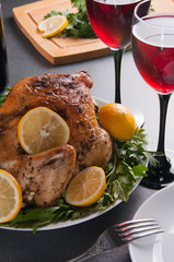 Garnished roasted turkey on holiday decorated table with glasses of red wine
