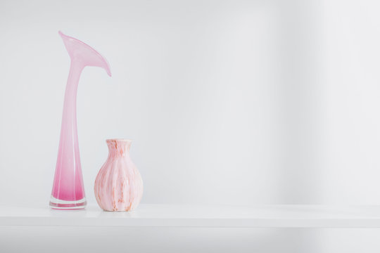 pink vases on white shelf
