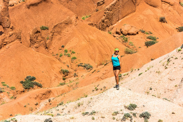 Fototapeta na wymiar The beautiful girl in orange rocks of the canyon Tale, Kyrgyzsta