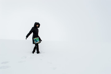 Fototapeta na wymiar Woman walking in a snowy field