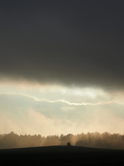 Dunkle Wolkenwand über kleiner Hütte auf dem Feld