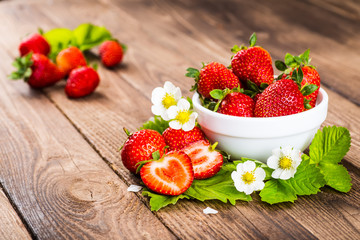 Strawberry on wood background. Strawberry with green leaves flow
