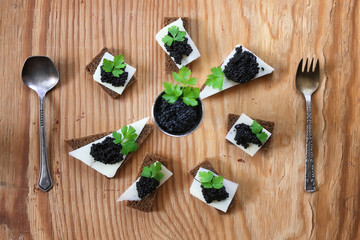 snack black caviar on a wooden background
