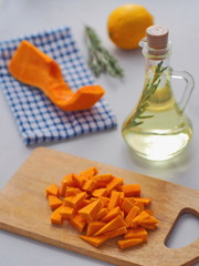 Cooking process. Fresh pumpkin pieces arranged on cutting board. Cooking with butternut squash and olive oil. Selective focus on the front.
