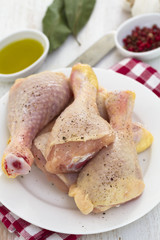 raw chicken on white dish on wooden background