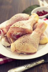 raw chicken on white dish on wooden background