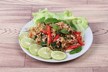 Fried spicy basil with minced pork topped sliced green lemon and and lettuce is top ten of popular Thai food.
