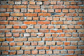 Red brick wall backgraund with darkened edges. Background of old vintage brick wall. Red brick wall texture grunge background perfect for design purposes.