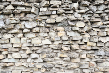 Gray pattern of old style design decorative cracked real stone wall surface with cement. Part of a stone wall, for background or texture. Antique natural stonewall background. Architectural background