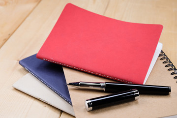 pen and book on wood background