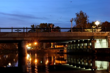 bridge with reflection in the river in the evening city