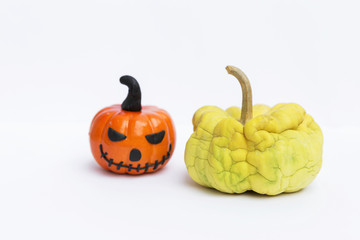 Old mini pumpkin and plastic halloween pumpkin on white background