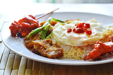 spicy stir fried crispy pork curry with egg and grilled pork stick