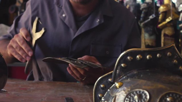 Craftsman called Puparo in Italian that works on a piece of the shield of a puppet.