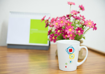  flowers with coffee cup on workspace.