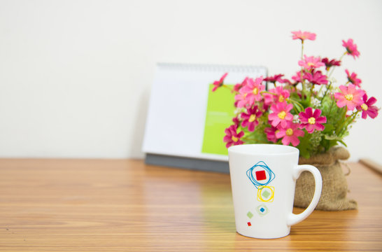 flowers with coffee cup on workspace.