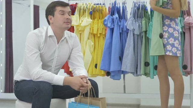 The young man wait the girl during the shopping