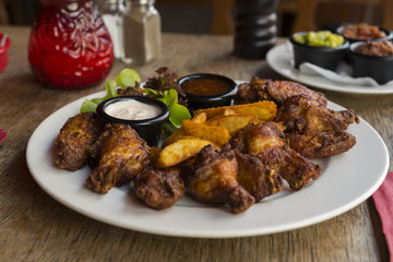 Barbecue Chicken Wings mit Country Potatoes Pommes und Sour Cream 