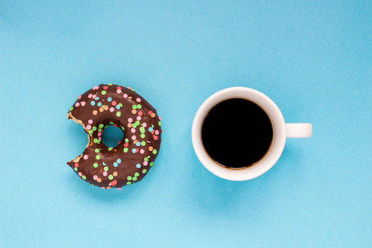 Chocolate donuts with coffee on the blue background.