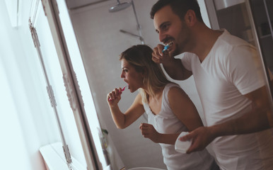 Couple washing teeth in morning