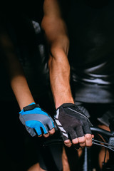 Hands of a  in a sports  gloves holding on to the steering wheel