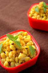 Dahi Boondi or Boondi Raita yogurt gram flour balls in a red bowl.