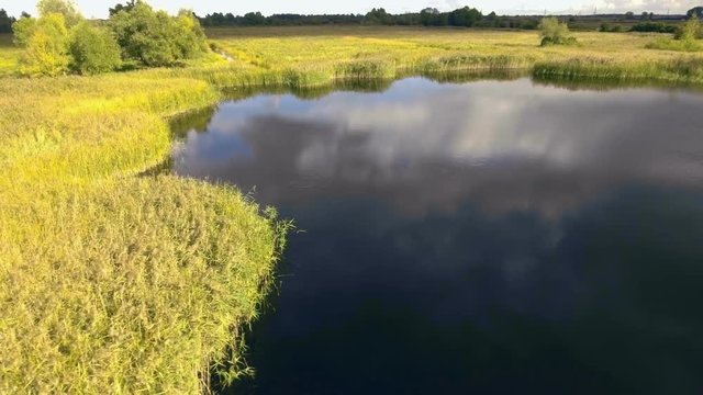 Panning shot of blue natural pond. Aerial view